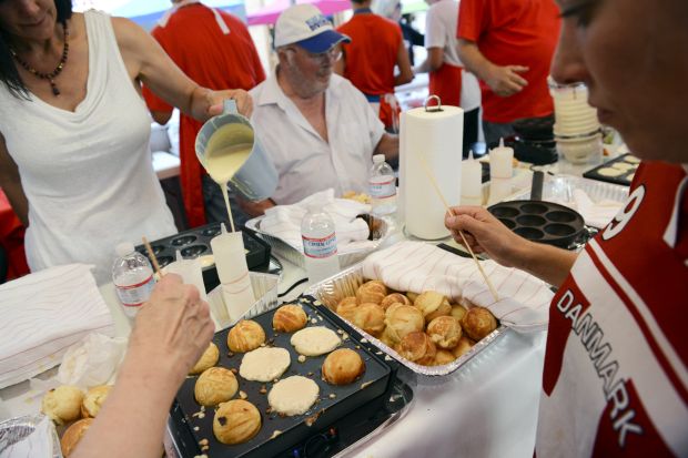 A group of Danish volunteers cook up aebleskivers, Danish pancake...